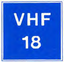 Blauw bord met de tekst "VHF 18" (voorbeeldkanaal). Betekenis: marifoonkanaal voor nautische informatie, bijvoorbeeld kanaal 18.